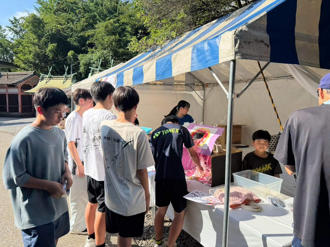 白い布をかけた台の上に商品を並べた店先と、順番を待つお客さんの列